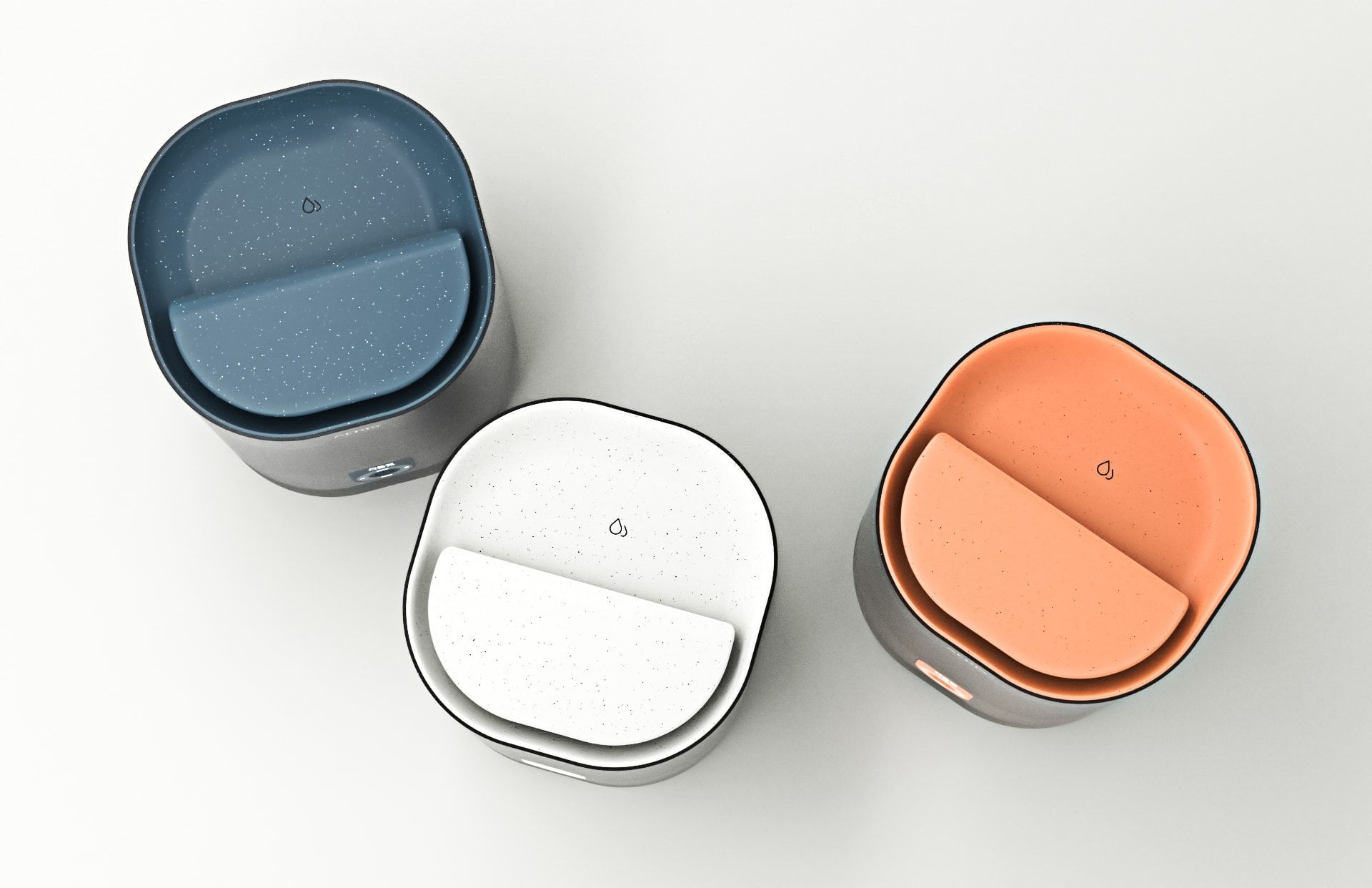 Three Aeris humidifiers seen from above in navy, white and orange, each with a speckled lid, on a pale surface.